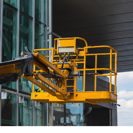 Aerial Lift RentalsA yellow aerial lift in front of a glass paned building.