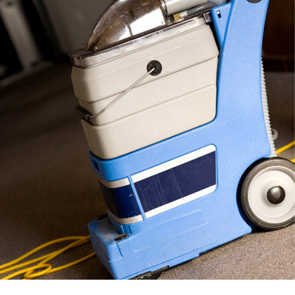 Floor Care & VacuumsA blue and grey carpet cleaner extractor sitting on a carpet next to a yellow extension cord.